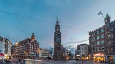 Munttoren Kulesi ve çiçek pazarı. Amsterdam şehir merkezinin panoramik günden geceye geçiş dönemi aşırı hızlanması tramvaylı sokak trafiği. Gün batımından sonra şehir manzarası. Hollanda