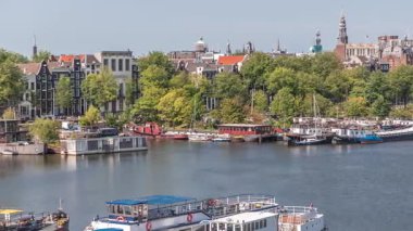 Oosterdok Limanı 'ndaki iskelede botları olan Amsterdam gökyüzü manzarası. Amsterdam Centraal İstasyonu ve Scheepvaarthuis yakınlarındaki geleneksel Hollanda mimarisi. Amsterdam, Hollanda