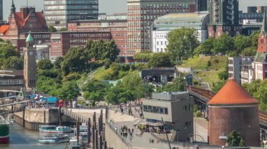 Jan Fedder Gezinti Alanı Hamburg, Almanya 'da canlı bir liman bölgesi. Gemiler ve tekneler Elbe Nehri 'nde ve arkasında ünlü binalar var. Rahatlama ve manzaralı güzellik