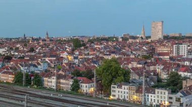Tren istasyonu yakınlarındaki Schaerbeek 'te Brüksel ufuk çizgisi üzerinde hava gününden geceye geçiş zamanı panoraması. Konut blokları, Saint-Servais Kilisesi ve belediye binası Belçika 'nın kırmızı çatılarıyla çevrili.