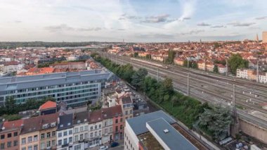 Brüksel Kuzey İstasyonu 'nun tren rayları, gelen ve giden trenlerle dolu. Schaerbeek akşam şehir manzarası kırmızı çatılar, sanayi bölgeleri ve bulutlu bir gökyüzü. Belçika