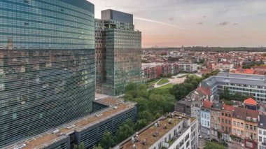 Brüksel kentsel manzarasının hava takvimi ofis gökdelenlerini gün batımında yerleşim alanlarıyla harmanlıyor. Yeşil park çimenleri, tarihi çatılar ve modern mimari, Belçika 'nın çeşitli şehirleri