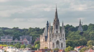 Belçika, Brüksel 'deki Notre Dame de Laeken kilisesinin hava akşam manzarası. Neo-gotik mimari tarihi cephelerle, yemyeşil park alanlarıyla ve pitoresk şehir manzarasıyla çevrili.