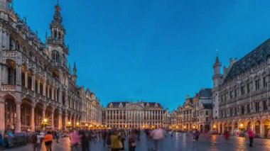 Belçika, Brüksel 'deki Grand Place Grote Markt' ın günden geceye geçiş dönemi aşırı hızlanması. Brabantine Gotik Belediye Binası, Maison Grand-Place ve tarihi şehir merkezinde gün batımından sonra turistler