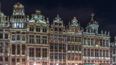 Belçika, Brüksel 'deki Büyük Yer Loncaları cephesinin gece sürati. Barok mimari zaman çizelgesinde yer alan tarihi sanat dernekleri ve UNESCO listesindeki kare üzerinde yürüyen insanlar