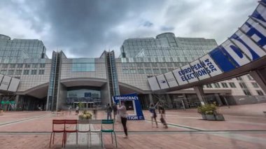Avrupa Parlamentosu 'nun Brüksel, Belçika' daki genel merkezinin zaman çizelgesi. Dramatik bulutlu gökyüzünün altındaki ikonik binaya giriş modern mimariyi ve küresel karar verme sürecindeki rolünü gözler önüne seriyor.