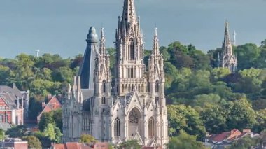 Belçika 'nın başkenti Brüksel' de Notre Dame de Laeken kilisesinin hava manzarası bulutların altında. Neo-gotik mimari tarihi cephelerle, yeşil park alanlarıyla ve pitoresk şehir manzarasıyla çevrili.