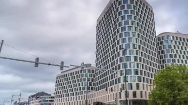 Baudouin Bulvarı, Brüksel, Belçika 'daki iş alanındaki trafik ve modern ofis binalarının zaman çizelgesi. Kavşağın yanındaki çağdaş kuleler bulutlu bir gökyüzünün altına park ederler.