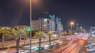 Riyad, Suudi Arabistan 'ın şehirsel gece zaman çizelgesinde aydınlık kuleler, gökdelenler, Kral Fahd Yolu ve yoğun trafik yer alıyor. Palmiyeler ve sokak lambaları alışveriş merkezinin yakınındaki ana otoyolda.