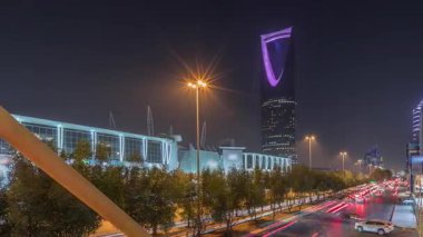Riyad 'ın panoramik gece zaman çizelgesine göre karayolu trafiği var. Aydınlatılmış modern binalar canlı manzaranın etrafını sarar. Krallık Kulesi Suudi Arabistan 'ın başkentinin en yüksek gökdelenidir..