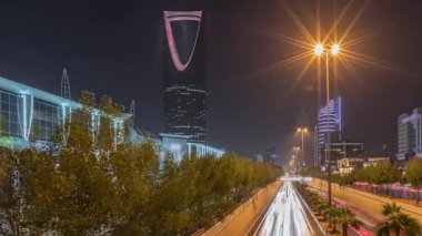 Riyad karayolu tüneli trafiğinin yer aldığı panoramik gece zaman çizelgesi, Krallık Kulesi Suudi Arabistan 'ın başkentinin en yüksek gökdeleni ve simgesi. Aydınlatılmış modern binalar çevre sahnesi
