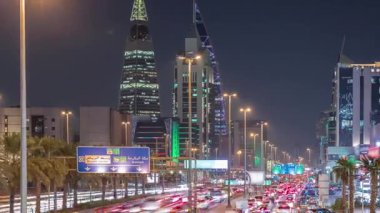 Riyad, Suudi Arabistan 'ın şehirsel gece zaman çizelgesinde aydınlık kuleler, gökdelenler, Kral Fahd Yolu ve yoğun trafik yer alıyor. Palmiyeler ve sokak lambaları şehrin içinden geçen ana otoyol boyunca uzanır..
