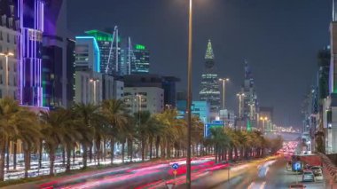 Riyad, Suudi Arabistan 'ın şehirsel gece zaman çizelgesinde aydınlık kuleler, cam gökdelenler, Kral Fahd Yolu ve yoğun trafik yer alıyor. Palmiyeler ve sokak lambaları şehrin içinden geçen ana otoyolda..