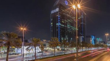 Suudi Arabistan, Riyad 'ın şehir manzarası gece zaman çizelgesi. Işıklı kulelerin, gökdelenlerin, King Fahd Yolu 'nun ve yoğun trafiğin panoramik görüntüsü. Palmiyeler ve sokak lambaları şehrin içinden geçen ana otoyolda.