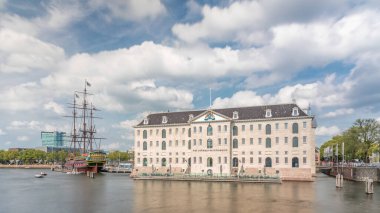 Denizcilik Müzesi 'nin hiperlapse' si ve Amsterdam 'ın deniz kenarı kopyası. Bulutlu mavi gökyüzü. Kültürel aktiviteleri, kanalları ve köprüleri meşhurdur. Amsterdam, Hollanda