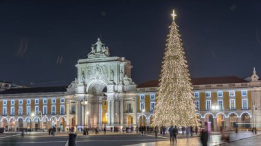 Lizbon 'daki ticaret meydanı, Noel' de yüksek bir ağaç ve geceleri kemerle aydınlandı. Dekorasyon ve tarihi mimarinin yer aldığı şenlikli atmosferin zamanlaması