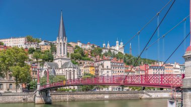 Aziz George Kilisesi, Quais de Saone ve Fourviere Bazilikası 'nın Fransa' nın Vieux Lyon kentindeki bir yaya köprüsünden hızlandırılmış zamanaşımı, tarihi mimari, yansımalar ve manzaralı nehir manzarası sergileniyor.