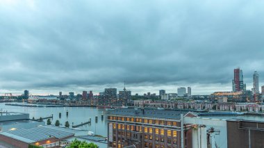 Rotterdam 'daki Katendrecht ve Maas Nehri' nin dramatik gökyüzü, Maashaven 'ın gündüz ve gece arası panoramik görüntüsü. Eski fabrika yakınlarındaki trafik ofis ve etkinlik alanına dönüştü
