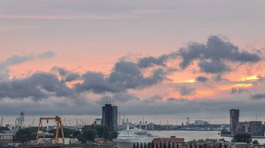 Maashaven Limanı 'nın hava zamanı, Hollanda Rotterdam' da günbatımında turuncu bulutlar. Rıhtım manzarası ve eski yolcu gemisi SS Rotterdam, şimdi Katendrecht 'e demirlemiş bir otel.