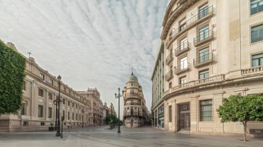 Avda boyunca yürüyen yayalar. De la Constitucion, Seville, İspanya 'nın Casco Antiguo bölgesindeki ana cadde. Edificio de la Adriatica ile zaman atlaması, tarihi binalar ve geçen tramvaylar