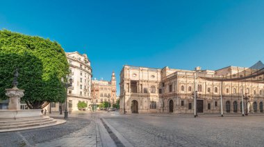 Panorama, Sevilla, San Francisco Plaza 'daki belediye binasının sabah saatlerini gösteriyor. Mavi gökyüzü altında geleneksel Endülüs binalarıyla çevrili Kasa Düşünceli, Plateresk mimari