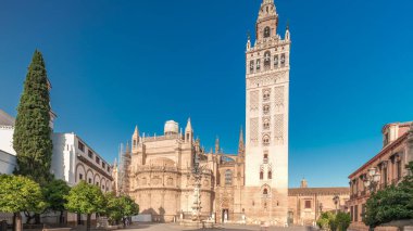 Seville Katedrali ve Giralda Kulesi 'nin Sevilla, İspanya' daki aşırı hızını gösteren panorama. Dünyanın en büyük gotik katedrali Virgen de los Reyes meydanında, mavi gökyüzünün altında.
