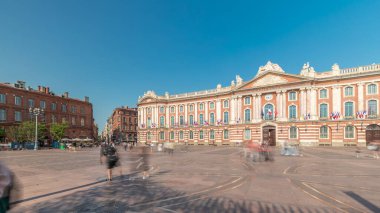 Capitole de Toulouse zaman çizelgesini gösteren panorama, Fransa 'nın Toulouse şehrinin tarihi belediye binası ve belediye kalbini, Capitole Meydanı' nda, çarpıcı mavi bulutlu gökyüzünün altında sergiliyor.