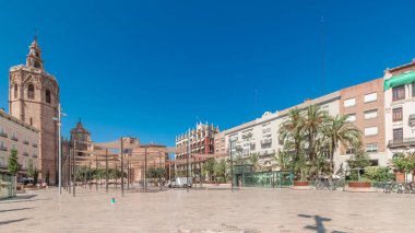 Panorama, İspanya, Valencia 'daki Plaza de la Reina' nın zaman çizelgesini gösteriyor. Tarihi bir kilise kulesi, hareketli kafeler ve sıcak Akdeniz mavi gökyüzünün altında merkezi bir çeşmesi olan canlı bir meydan..