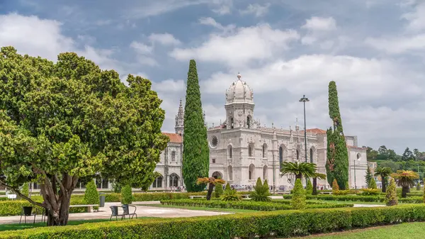Mosteiro dos Jeronimos ve bahçede çimenliği olan yeşil ağaçlar, Lizbon, Portekiz 'in Belem bölgesinin zaman diliminde yer almaktadır. Manueline tarzı (Portekizce geç Gotik). Mavi gökyüzünde bulutlar