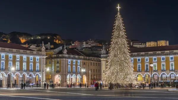 Lizbon 'daki ticaret meydanı, Noel' in aşırı hızıyla aydınlandı. Yükselen bir ağaç ve geceleri kutlayan kalabalıkla. Bir tepenin üzerindeki şenlikli atmosfer dekorasyonları ve tarihi mimarinin zamanı.