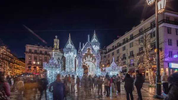 Lizbon, Portekiz 'deki Luis de Camoes meydanında aydınlatılmış şatoyla Noel süslemelerinin gece süreleri. İnsanlar şenlikli ışıkların ve tarihi mimarinin etrafında dolanıyor. Ön görünüm