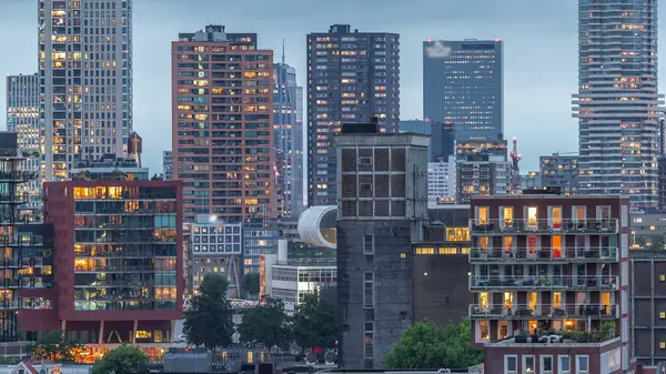 Rotterdam, Hollanda 'daki Katendrecht yarımadası ve Maashaven limanının hava ve gece geçiş zamanı. Günbatımından sonra parlayan pencereleri olan modern gökdelenler.