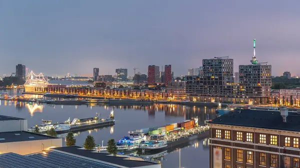 Güneş doğmadan önce Maashaven 'daki kuleler üzerindeki hava manzarası demirli gemilerle, Katendrecht ve Maas Nehri' yle, Rotterdam 'la geçiş zamanlarını gösteriyor. Aydınlatılmış fabrika ofis ve olay alanına dönüştürüldü