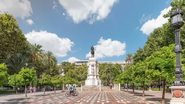 Seville 'deki Plaza Nueva' da, yeşil ağaçlar ve tarihi binalarla çevrili Kral San Fernando 'nun binicilik heykeli yer alıyor. Mavi gökyüzünün altında manzaralı bir şehir alanı
