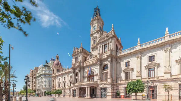 Valencia Belediye Binası (Ajuntament de Valencia) Plaza de Ayuntamiento 'da zamanaşımına uğradı. Mavi gökyüzünün altında saat kulesi olan tarihi bir bina. İspanya 'nın ana meydanında gezinen insanlar
