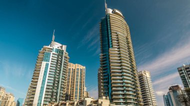 Dubai Marina modern uzun kuleleri, Birleşik Arap Emirlikleri 'ndeki gezinti zamanlarından suya yansıdı. Dubai 'de bir bölge ve yapay bir kanal. Mavi bulutlu gökyüzü
