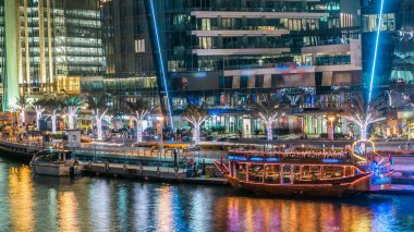 Dubai Marina rıhtımı, yatları ve Dubai 'deki köprüden modern kuleleri olan gece zaman çizelgesi, Birleşik Arap Emirlikleri. Eski turistik tekne.