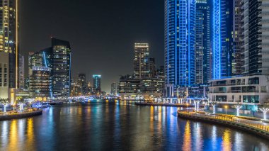 Dubai Marina 'da yatları ve Dubai' deki köprüden restoranları olan modern kuleleri olan bir gezinti alanı, Birleşik Arap Emirlikleri. Yapay kanalla aydınlatılmış bölge