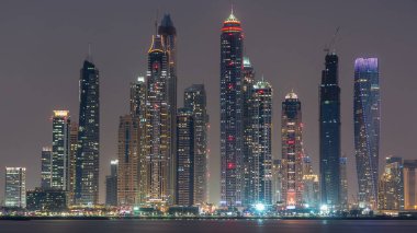 Dubai Marina ufuk çizgisi günden geceye geçiş zamanı panorama Palm Jumeirah, Dubai, BAE 'den görüldüğü gibi. Dubai 'nin bu kısmında 50 kattan fazla gökdelen var.