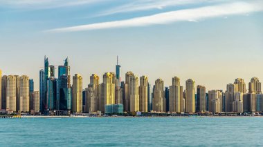 Jumeirah Sahili Residence, gün batımında gökyüzünde Palm Jumeirah 'dan deniz zaman ayarlı olarak görülüyor. Akşam ışığında birçok gökdelen. Dubai, Birleşik Arap Emirlikleri