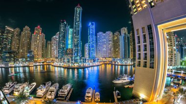 Dubai Marina gezinti güvertesi, Dubai 'deki alışveriş merkezinin balkonundan Kanal etrafında kuleleri olan yatlar, Birleşik Arap Emirlikleri.