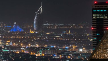 Gece vakti büyük, modern bir şehrin gökdelenler, ofis binaları, oteller aydınlatılmış gece trafiği manzarası. İş Körfezi, Dubai, Birleşik Arap Emirlikleri.