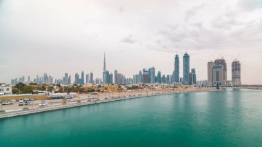 Yeni Dubai su kanalı manzaralı şehir manzarası bulutlu gün timelapse, Birleşik Arap Emirlikleri. Gökdelenler suya yansıyan. Köprüsü'nden görüntülemek
