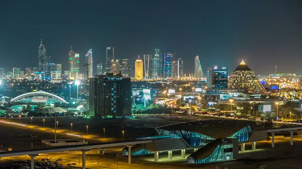 Gece Dubai şehir merkezindeki gökyüzü zaman çizelgesi. Şeyh Zayed 'in çok sayıda aydınlık kulesi, gökdelenleri ve metro istasyonu olan üst manzarası. Yollarda trafik vardı. Ünlü simge.