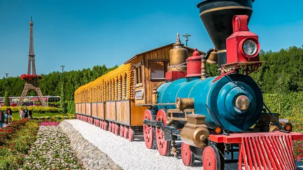 Güneşli bir günde 45 milyondan fazla çiçekle Dubai 'deki mucize bahçe zamanı treni Birleşik Arap Emirlikleri. Arka planda Eifel kulesi modeli