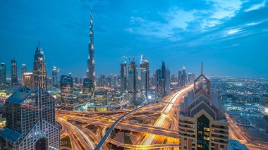 Modern gökdelenler ve yoğun gece otoyolları Dubai şehir merkezindeki lüks geçiş zamanlarında. Kule çatısından üst hava manzarası. Yol kavşağı trafiği. Dubai, Birleşik Arap Emirlikleri