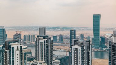 Dubai'nin iş bay önce günbatımı timelapse kuleleri. Çatı görünümü bazı gökdelenler ve yapım aşamasında yeni kuleleri. Bulutlu gökyüzü