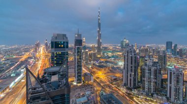 Dubai 'nin panoramik silueti günden geceye geçiş zamanı, Birleşik Arap Emirlikleri. Ünlü gökdelenler kule çatısı manzaralı. Güzel bulutlu gökyüzü. Renkli seyahat ve iş geçmişi