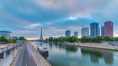 Eyfel Kulesi Seine Nehri 'nde ve Fransa' nın Paris şehrinde teknelerle renkli gündoğumu zamanı. Grenelle Köprüsü 'nden hava görüntüsü. Modern binalar ve yol trafiği. Dramatik bulutlar