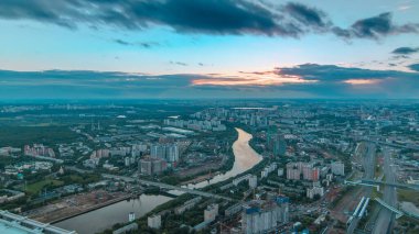 Moskova 'nın günbatımı panoramik zaman çizelgesinin hava üstü görüntüsü. Moskova 'nın iş merkezindeki gözlem platformundan şehir manzarası. Moskova nehri ve yaz günü yollarda trafik